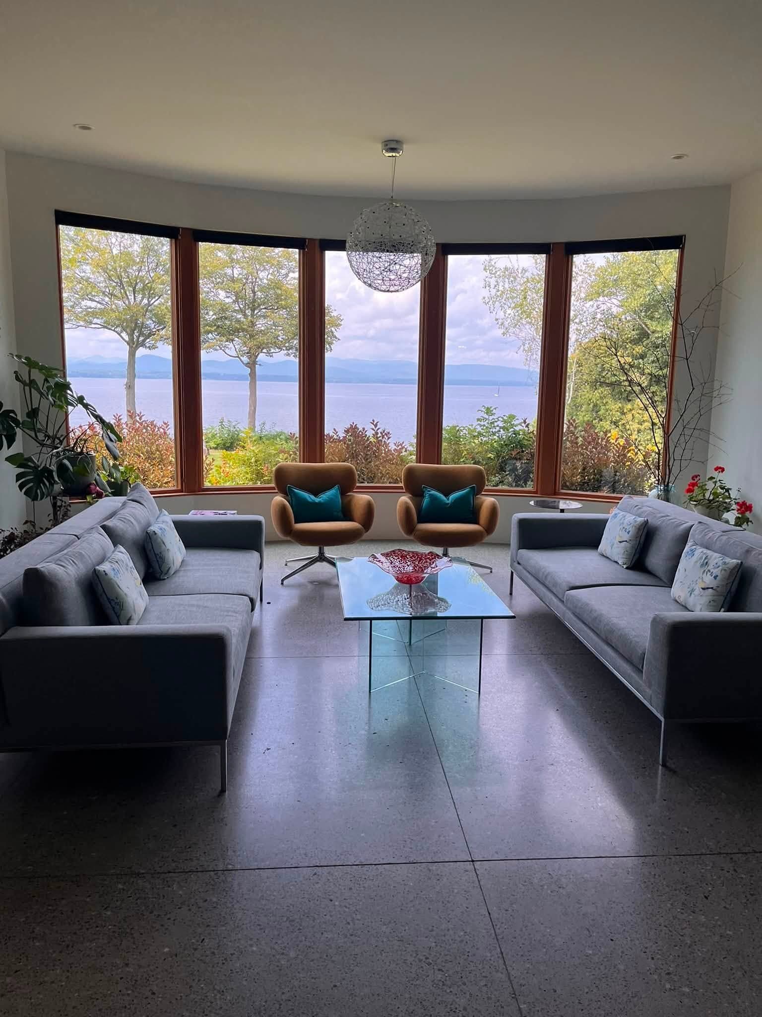 A living room JC Crew cleaned, big windows looking out over Lake Champlain