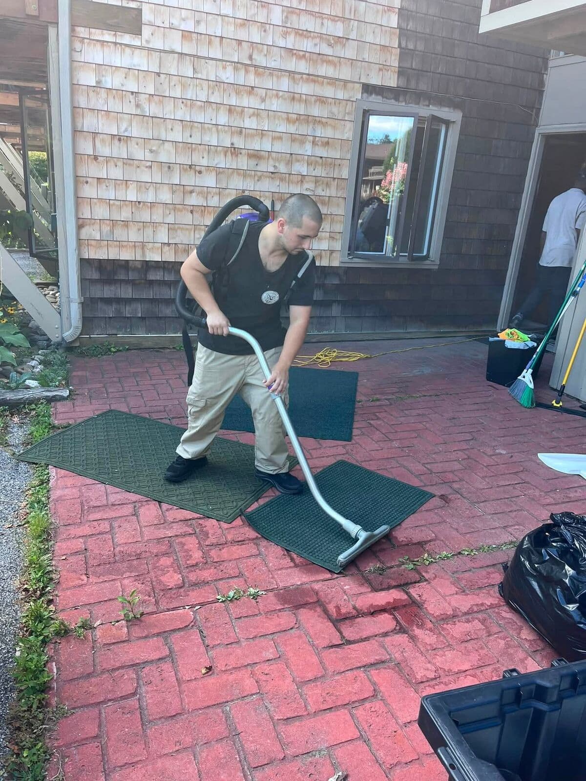 Crew member vacuuming an outdoor mat