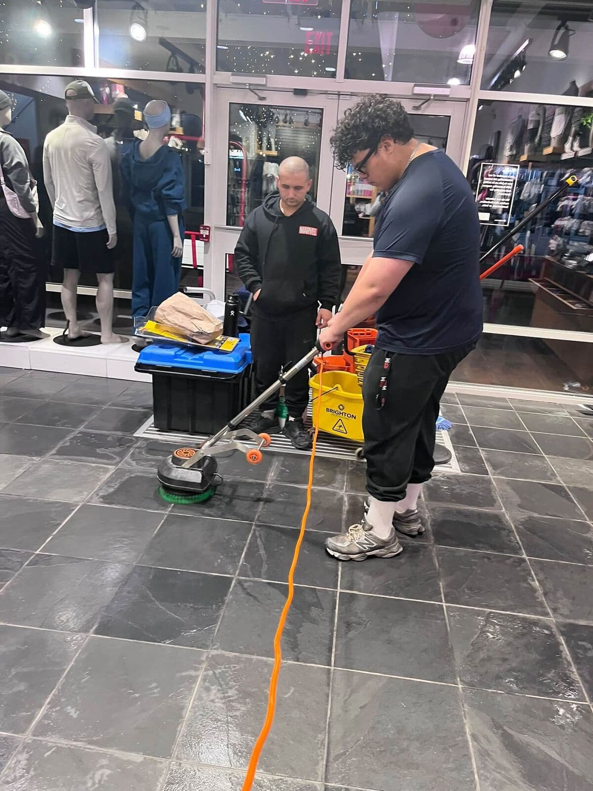 Crew scrubbing a retail floor with a floor machine