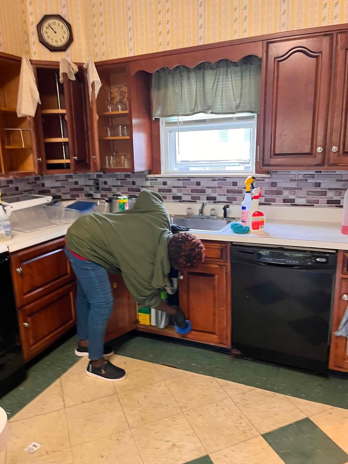 Crew member scrubbing kitchen cabinets