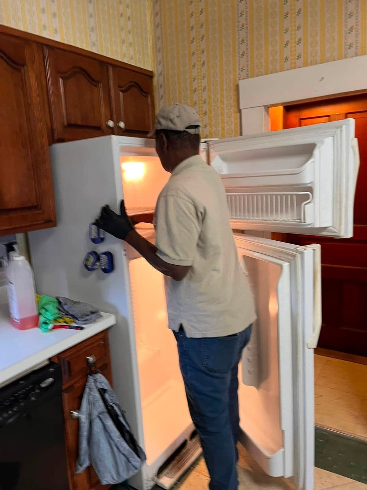 Crew member cleaning out a refrigerator
